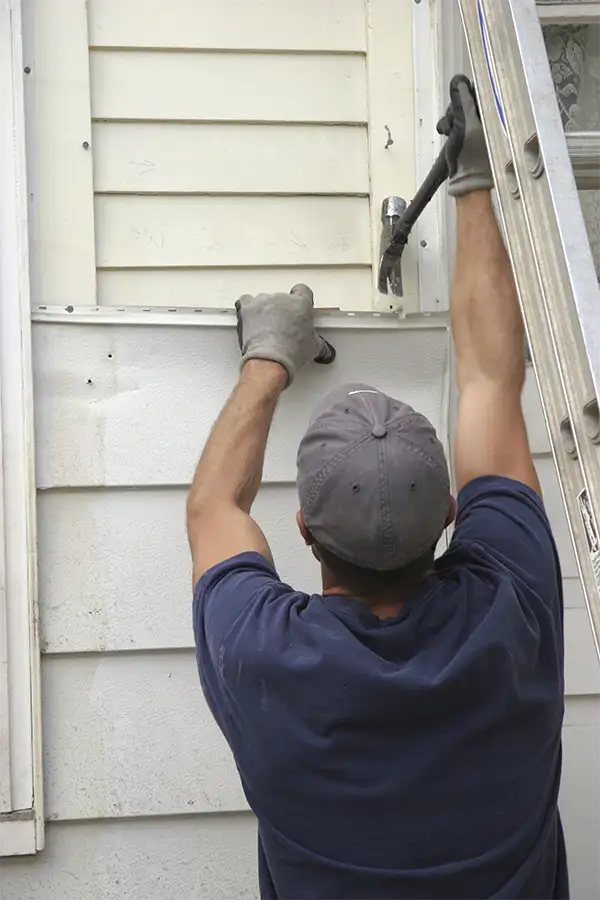 professional removes nails holding up old house siding to make room for new siding installation - Clinton County, IL
